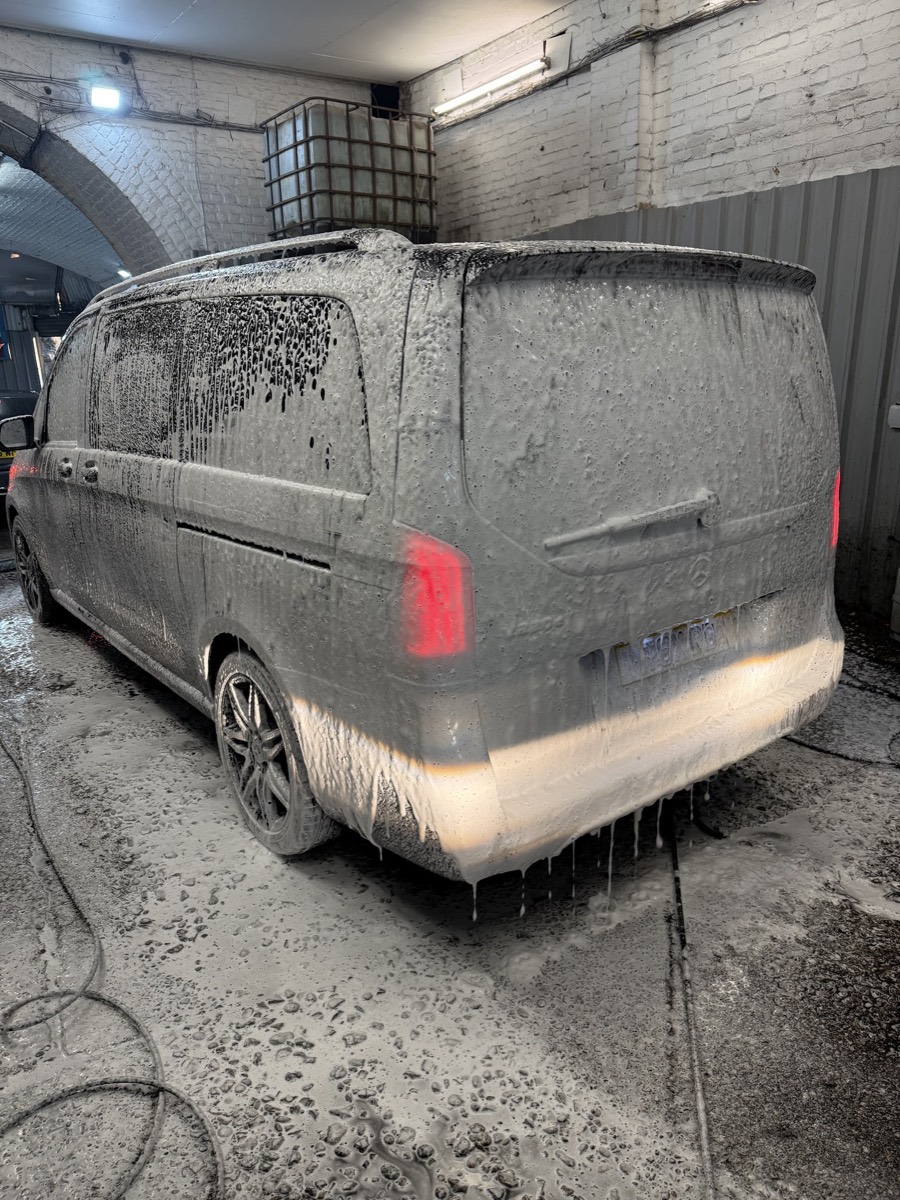 A van covered in thick snow foam during a foam bubble wash at Miami Car Wash