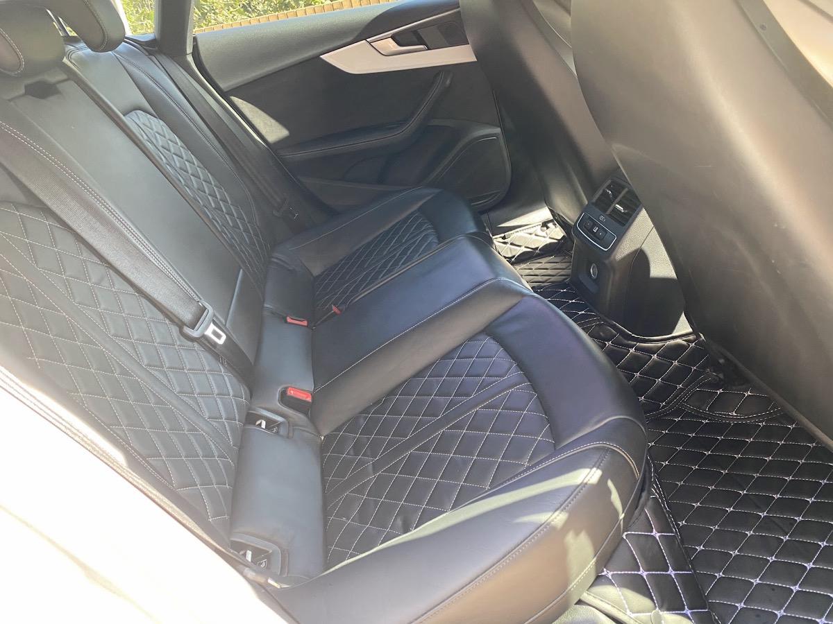 Cleaned and conditioned black diamond-stitch leather seats after an interior valet