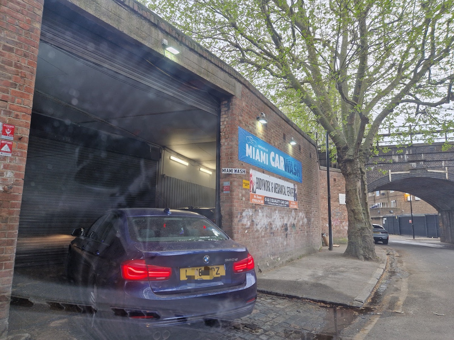 The Miami Car Wash entrance and sign on Rounton Road, Bow, under the railway bridge